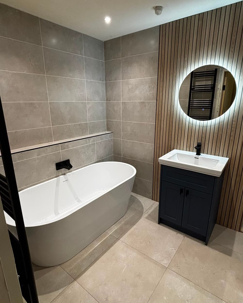 Finished bathroom by SMM — freestanding bath, backlit mirror and oak slat wall
