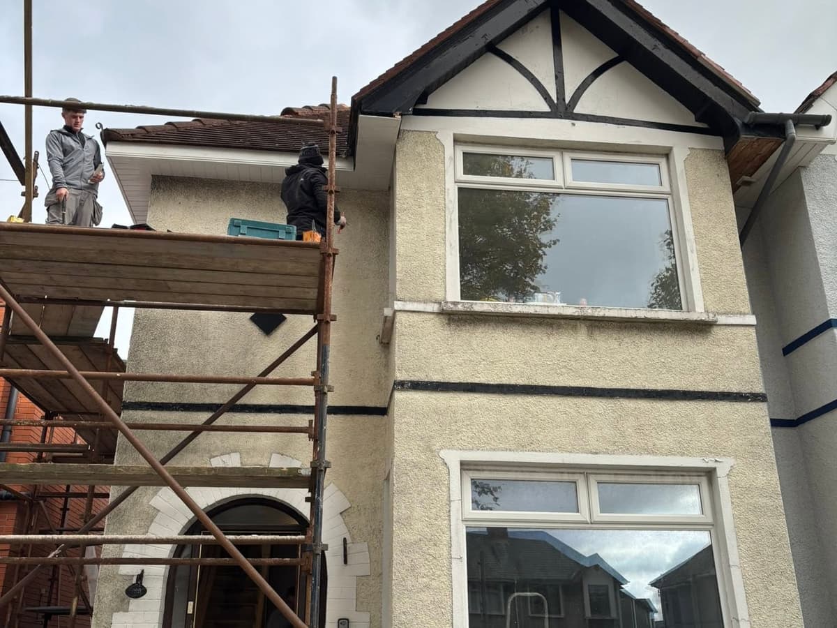 Before: the house mid-renovation under scaffolding, with the old pebbledash render