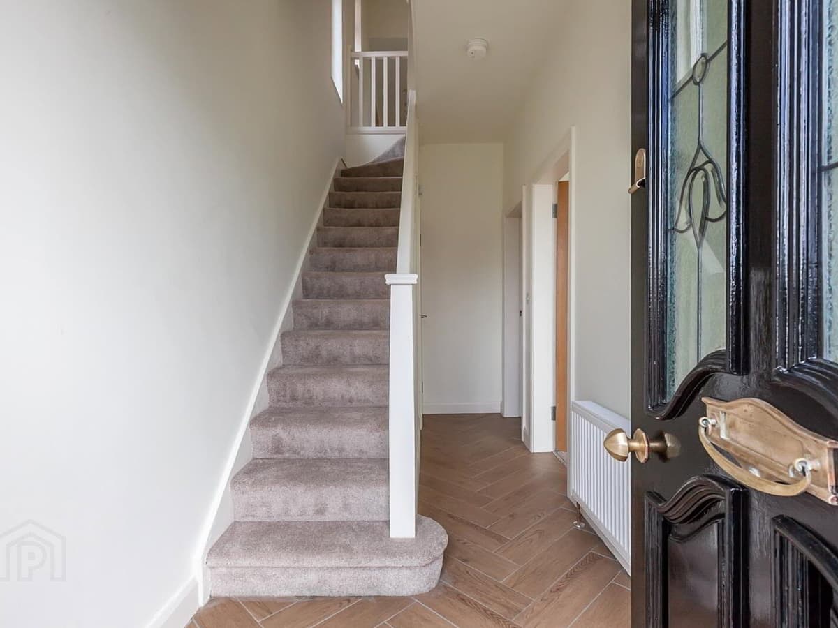 After: the finished hallway — carpeted stairs, painted balustrade and herringbone-style tiled floor