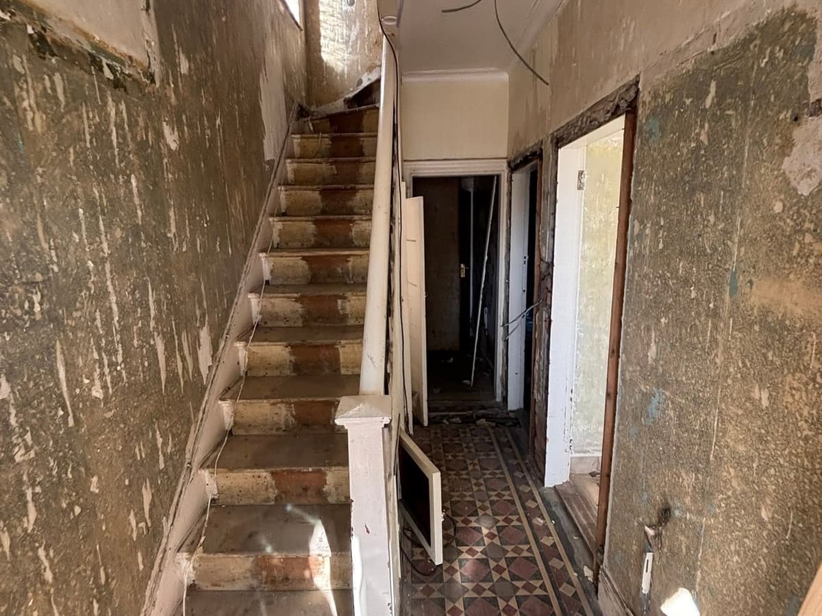 Before: the stripped-back hallway and staircase, walls back to plaster