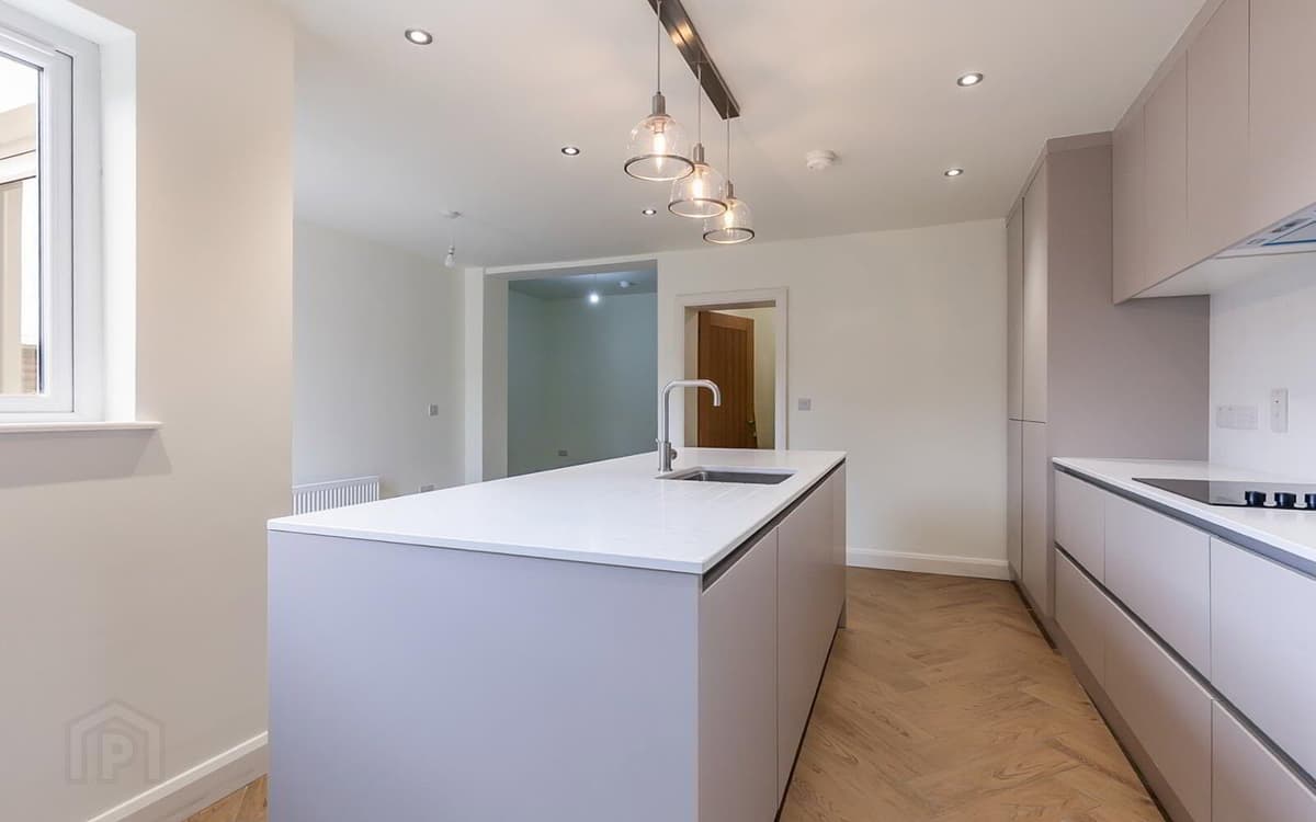 Open-plan kitchen with island inside a finished Belfast extension